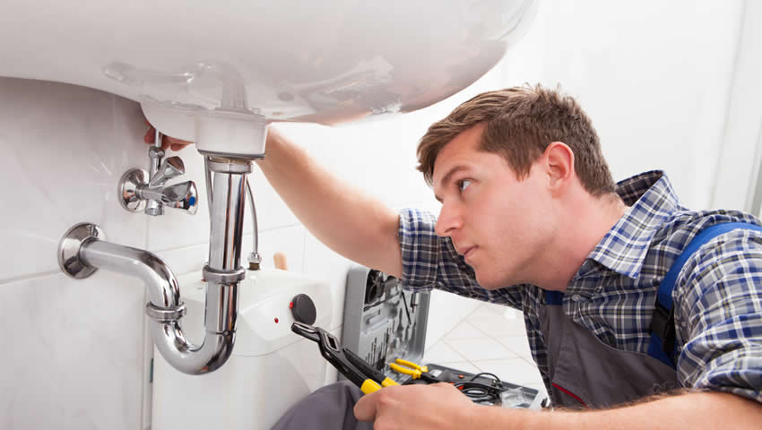 plumber unclogging drain